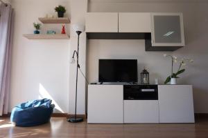 uma sala de estar com uma televisão num armário branco em Magoito Sea View Apartment em Lisboa