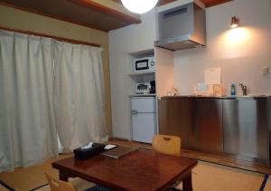 een keuken met een houten tafel en een koelkast bij Address Nozawa Japanese Room / Vacation STAY 22751 in Nozawa Onsen