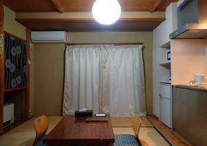 een kamer met een tafel en stoelen en een raam bij Address Nozawa Japanese Room / Vacation STAY 22751 in Nozawa Onsen