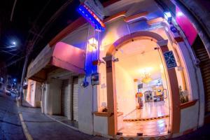 un bâtiment avec une arche dans une rue la nuit dans l'établissement Hotel Los Girasoles, à Tepic