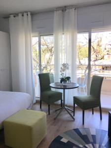 Schlafzimmer mit einem Bett, einem Tisch und Stühlen in der Unterkunft Arthur Properties Bel Air in Cannes