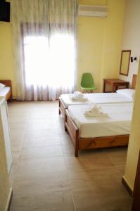 1 dormitorio con 2 camas y ventana en Sotiras Rooms, en Skala Sotiros