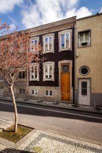 een gebouw met een boom voor een straat bij Fishtail Sea House in Matosinhos