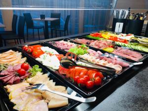 een buffet met veel verschillende soorten vlees en groenten bij Jet Hotel Zurich Airport in Rümlang