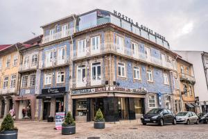 un grande edificio blu con finestre bianche su una strada di In Barcelos Hostel & Guest House a Barcelos