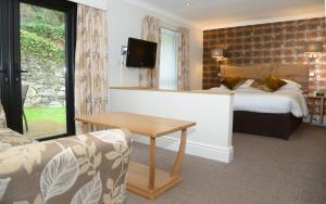 una camera d'albergo con letto, tavolo e divano di The Waterloo Hotel a Betws-y-coed