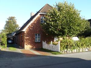 een stenen huis met een wit hek ervoor bij Ferienwohnung Seidler in Rendsburg