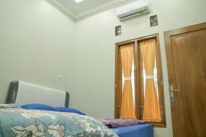 een slaapkamer met een bed en een houten deur bij M Stay Guest House Jogja in Yogyakarta