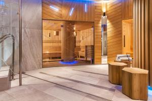 a bathroom with a shower and a bench in a room at Ensana Thermal Hévíz in Hévíz