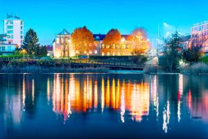 Blick auf eine Stadt mit einem Fluss in der Nacht in der Unterkunft Strandhotel Alte Donau in Wien