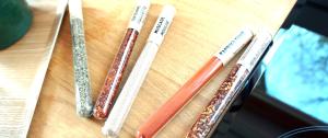 four different colored toothbrushes sitting on a wooden table at Tiny House Dreischwesternherz in Trier