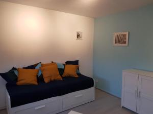 1 dormitorio con 1 cama con almohadas de color naranja y azul en Le Bellevue, en Colmar