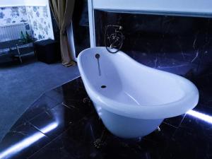 baño con lavabo blanco en el suelo negro en Hotel Tara, en Kielce