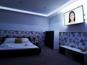 1 dormitorio con 1 cama y TV en la pared en Hotel Tara, en Kielce