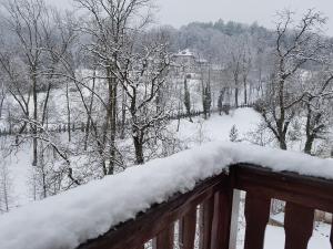 a balcony covered in snow with trees and a house at Hotel Esprit in Braşov