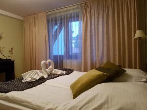 two swans sitting on a bed in a bedroom at Hotel Esprit in Braşov