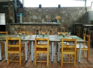 uma grande mesa de madeira com cadeiras e uma lareira em Urban Lodge em Bujumbura