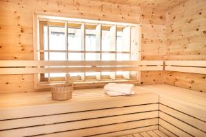 una sauna con ventana en una cabaña de madera en Hotel & Alpin Lodge Der Wastlhof, en Niederau