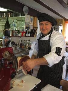 Un uomo in piedi in una cucina che prepara il cibo di Dino's Trinacria a Friesenheim