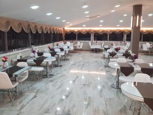 einen Bankettsaal mit Tischen und weißen Stühlen in der Unterkunft Ismira Hotel Ankara in Ankara