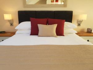 una camera da letto con un letto con cuscini rossi e bianchi di Compston House B & B ad Ambleside