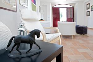 una estatua de un caballo sobre una mesa en una sala de estar en Quinta dos Álamos Agroturismo, en Golegã