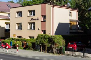 un edificio con una macchina rossa parcheggiata di fronte di Willa Marcela a Dziwnówek