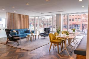 ein Wohnzimmer mit einem blauen Sofa und Stühlen in der Unterkunft Harvard Square Hotel in Cambridge