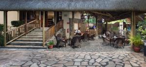 a patio with chairs and tables and a staircase at Le Palmiste Resort & Spa in Trou aux Biches