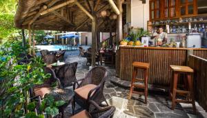 a restaurant with a bar with chairs and a bartender at Le Palmiste Resort & Spa in Trou aux Biches