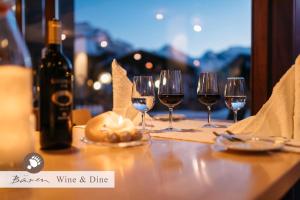 - une table avec des verres à vin et une bouteille de vin dans l'établissement Alpenkräuter Hotel Bären, à Wengen