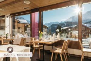 un restaurant avec vue sur les montagnes dans l'établissement Alpenkräuter Hotel Bären, à Wengen