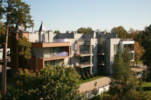 une image d'un bâtiment avec des arbres au premier plan dans l'établissement Sonia Apartments, à Jurmala