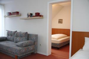 a bedroom with a couch and a bed and a mirror at Hotel Garni Kaiserpfalz in Goslar