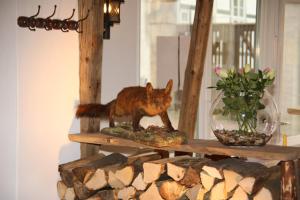 a wooden fox figurine on a shelf with a plant at Hotel Garni Kaiserpfalz in Goslar