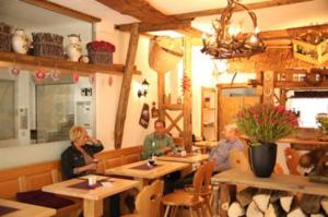 a group of people sitting at tables in a restaurant at Hotel Garni Kaiserpfalz in Goslar