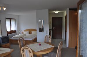 una camera con un letto e un tavolo e un letto e una camera di Appartements Waldrose a Titisee-Neustadt