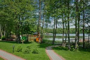 un parc avec un lac, des arbres et un chemin dans l'établissement Vila Viesai, à Trakai