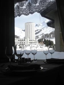 a group of wine glasses sitting on a table in front of a window at Hotel Biancaneve in Sestriere