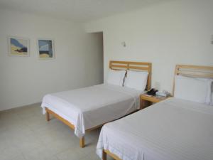 ein Hotelzimmer mit 2 Betten und einem Telefon in der Unterkunft Sotavento Hotel & Yacht Club in Cancún