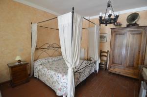 1 dormitorio con cama con dosel y armario de madera en Agriturismo La Pisana, en Pisa