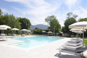 una piscina con tumbonas y sombrillas en Agriturismo La Pisana, en Pisa