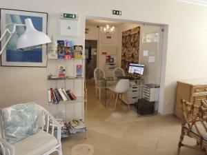 een woonkamer met een tafel en een bureau met een computer bij Hotel Mar Azul in Lagos