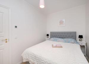 um quarto branco com uma cama com uma bandeja em Modern quiet 2 bedroom apartment near City center em Pärnu