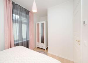 um quarto com uma cama branca e uma janela em Modern quiet 2 bedroom apartment near City center em Pärnu