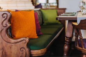 a bench with colorful pillows on it next to a table at Gutshof Sagmühle in Bad Griesbach