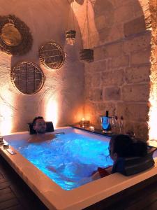 Ein Mann und eine Frau sitzen in einem Whirlpool in der Unterkunft Le Fornaci Imperial Lodge & Spa in Gravina in Puglia