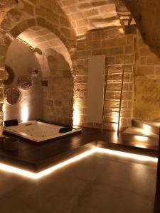 Zimmer mit einer Badewanne in einer Ziegelwand in der Unterkunft Le Fornaci Imperial Lodge & Spa in Gravina in Puglia