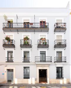 - une façade blanche d'un bâtiment avec balcon dans l'établissement ELEVEN Real de la Carretería, by Homing U, à Séville