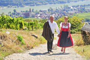 a man and a woman walking down a path with a dog at Gästehaus Turm Wachau in Weissenkirchen in der Wachau